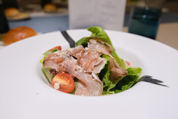 parma ham vegetable salad on white plate