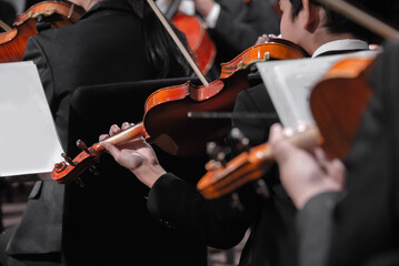 group of symphonic orchestra musicians playing classical music on stage