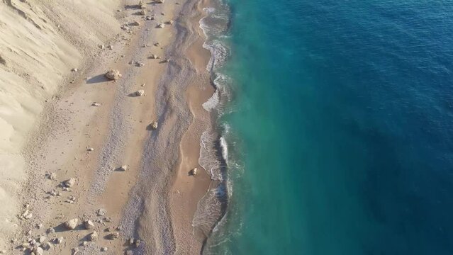 Drone shot of beautiful scenic beach with white sand and blue sea water, sunset, sunrise. Greece, Egremni beach of Lefkada island.