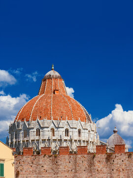 Pisa famous landmarks: Baptistry and Cathedral medieval domes, seen from outiside the city ancient walls (white copy space above)
