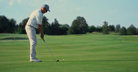 Professional athlete playing golf outdoors. Man walking golfing course in summer