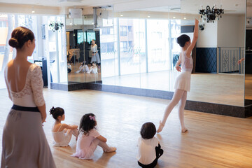 子供に手本を披露するバレエダンサー