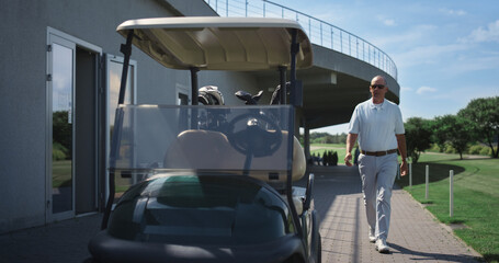 Rich golf player walking in driving cart. Luxury old man sit at country club.
