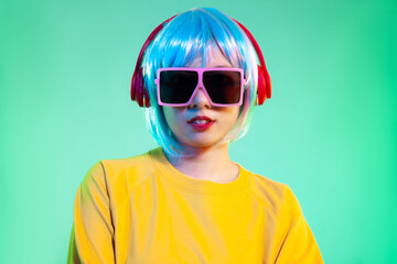 young asian women in red headphones posing isolated on neon green backgrounds. Human emotions, facial expression concept