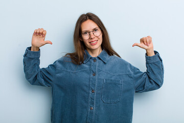 young adult pretty woman feeling proud, arrogant and confident, looking satisfied and successful,...