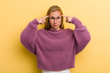 young adult blonde pretty woman with a serious and concentrated look, brainstorming and thinking...