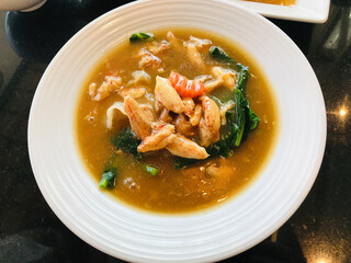 Fried noodles with kale and crab's claws meat in gravy sauce.