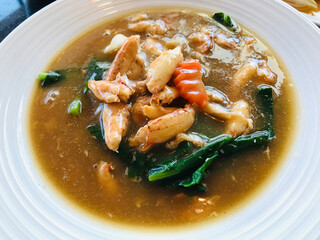 Fried noodles with kale and crab's claws meat in gravy sauce.