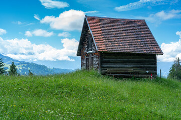 Fototapeta na wymiar alter Heustadel, Hütte auf einem Hügel, Holzschopf am Waldrand, kleines Haus mit Aussicht über das Rheintal. sonniger Tag mit kleinen Wolken