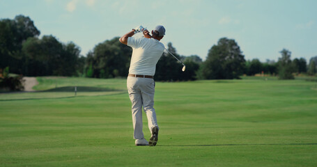 Old man play golf on grass fairway. Pro player swing club hitting ball outside.