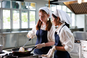 Group of student girl learning. Cooking class. culinary classroom. group of happy young woman multi - ethnic students are focusing on cooking lessons in a cooking school.