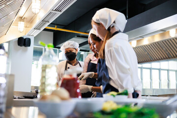 Senior asian woman chef teach student. Cooking class. culinary classroom. group of happy young...