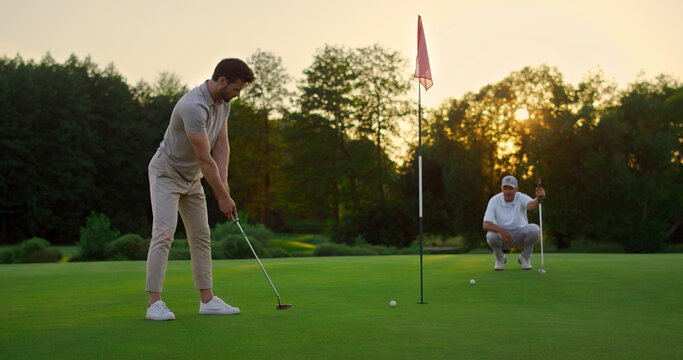 Golfers Team Hitting Ball On Sunset Field Course. Two Players Missing Golf Shot.