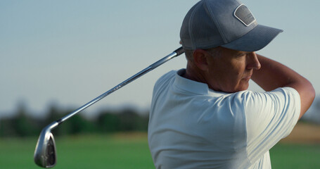 Sport man play golf match game on fairway. Senior player swinging golfing club.