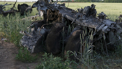 Downed military transport aircraft. Russian aggression in Ukraine. The remains of a burned-out aircraft on the field.