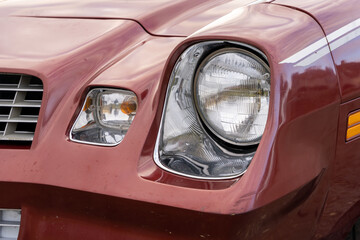 front headlight is a close-up of an old powerful classic American car