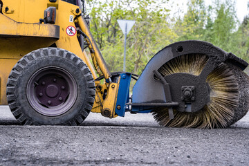 Cleaning of garbage from the road. a rotating mechanical machine brush