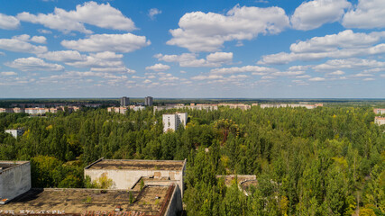Aerial view abandoned buildings and streets overgrown with trees in city Pripyat near Chernobyl nuclear power plant. Drone shot Exclusion Zone in summer. Radiation