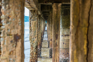 Naklejka premium View Under the bridge walkway at the pier from the beach to the sea.Thailand.