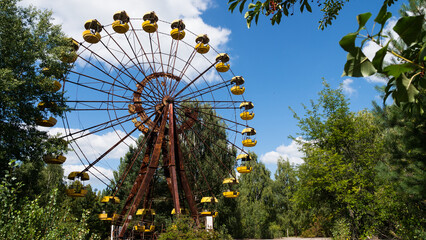 Ferris wheel in the ghost city of Pripyat after explosion of the fourth reactor Chernobyl nuclear power plant. Exclusion radioactive zone on a sunny summer day, Ukraine. Radiation, catastrophe