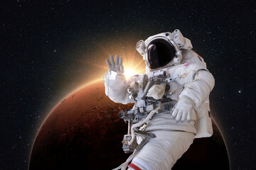 Successful astronaut in a space suit levitates in space and explores the amazing red planet Mars...
