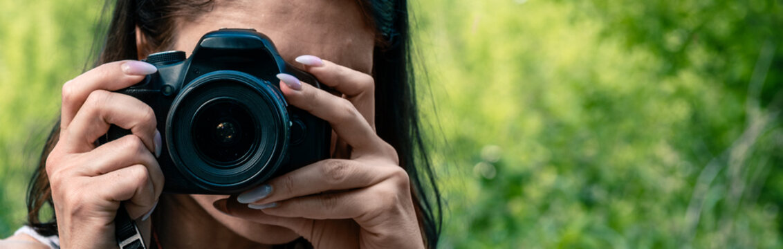 Young woman with a camera taking pictures outdoor.
