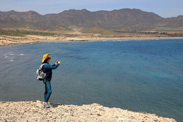 Fototapeta na wymiar almería mujer fotografiando playa costa senderista turista playa genoveses 4M0A3895-as22