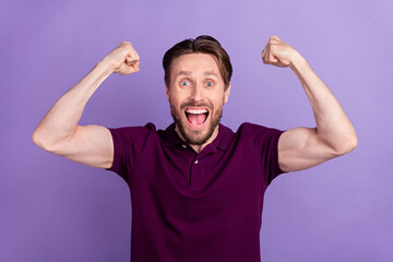 Photo of young cheerful man celebrate luck fan hooray fists hands lottery isolated over violet...