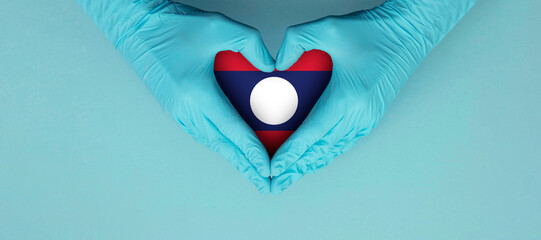 Doctors hands wearing blue surgical gloves making hear shape symbol with laos flag