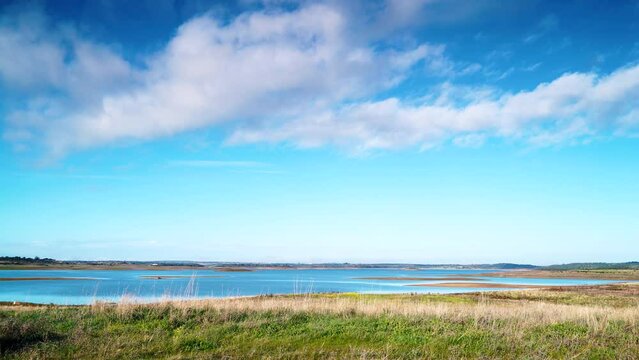 Time lapse of clouds moving over Alqueva Dam artificial lake at Luz village, Alentejo tourist destination region, district of Evora, Portugal Europe.