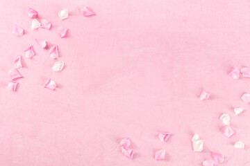 Floral background with rose petals, overhead flat lay shot on pink with copy space, a greeting card design template