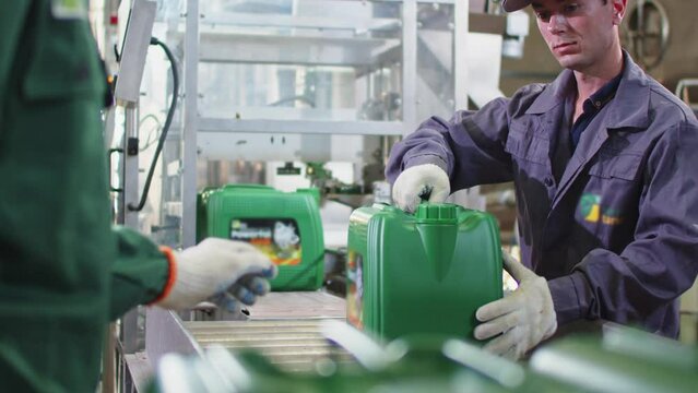 Worker on Production Line Taking the Canister