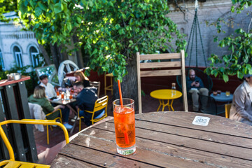 Sunny cafe with customers and aperol cold drinks in historical ukrainian capital, Kyiv