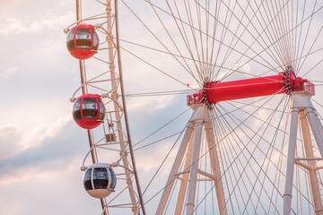 Ferris wheel in amusement park against sky background. Entertainment and fair concept. Close-up view of cabins and gondolas