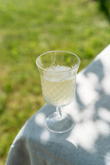 Summer cold drink in glass, lemonade on table in sunny day