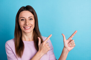 Photo of young cheerful girl indicate fingers empty space banner select promotion isolated over...