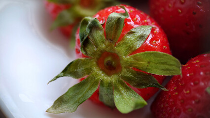 Juicy large garden strawberries on a plate close-up