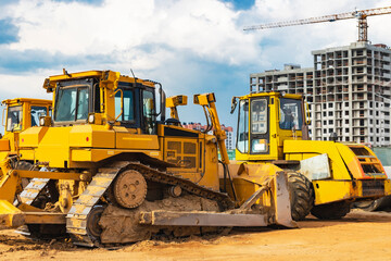 Bulldozer machine is leveling construction site. Earthmover with sky background. close-up. construction heavy machinery.