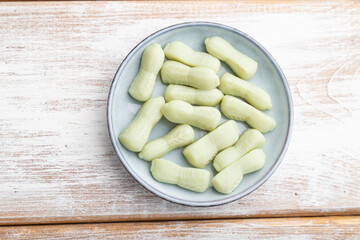 Jelly celery candies on white wooden background. close up, top view.