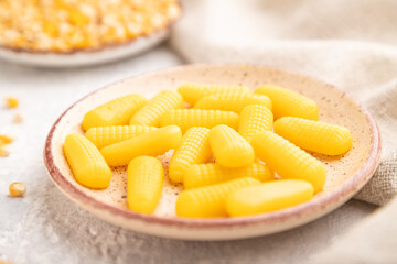 Jelly corn candies on gray concrete background. close up, side view, selective focus.