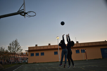 Silhouette of children playing basketball in the yard