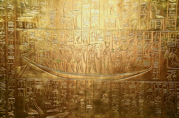 A golden wall with engraved Egyptian symbols, the tomb of pharaoh Tutankhamun