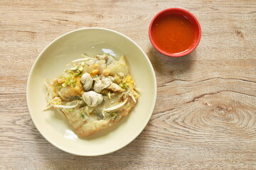 fried oyster with egg omelet and bean sprout on plate dipping chili sauce