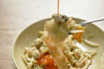 fried oyster with egg omelet and bean sprout on plate dipping chili sauce