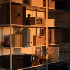 Modern home office interior design. White storage shelves with rattan boxes, decorations. Neutral...