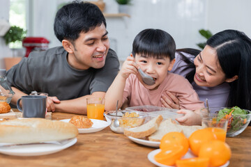Happy Asian family, young boy eating healthy food together