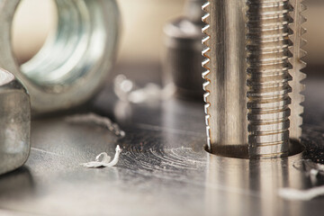 Thread tap drill steel billet with drill bit on background. Working cutter.