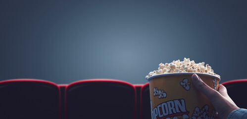 Woman eating popcorn at the movie theater - obrazy, fototapety, plakaty