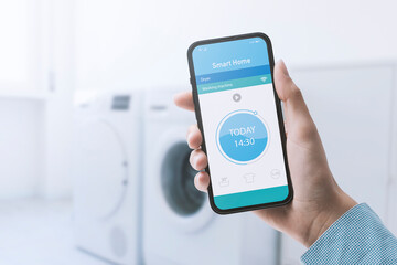Woman controlling her washing machine from her phone