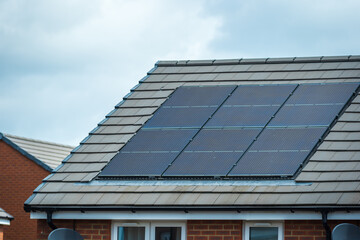 Solar panels mounted on the roof of a modern new-build house in England UK